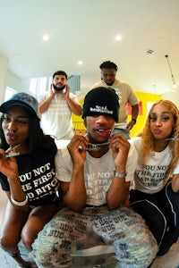 a group of people posing in front of a t - shirt