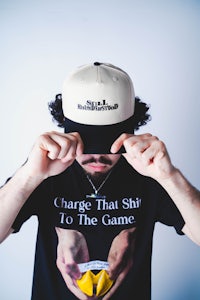 a man wearing a hat that says charge's that shitty to the game