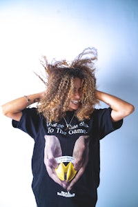 a woman with curly hair wearing a t - shirt