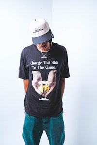 a man wearing a t - shirt that says charge that sh*t to the game